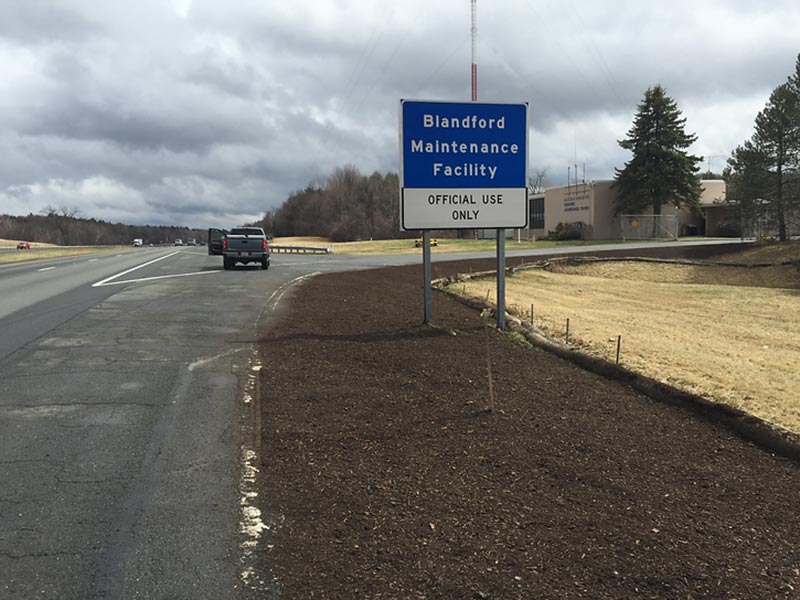 Roadside area with fresh mulch next to a highway and a sign for Blandford Maintenance Facility.